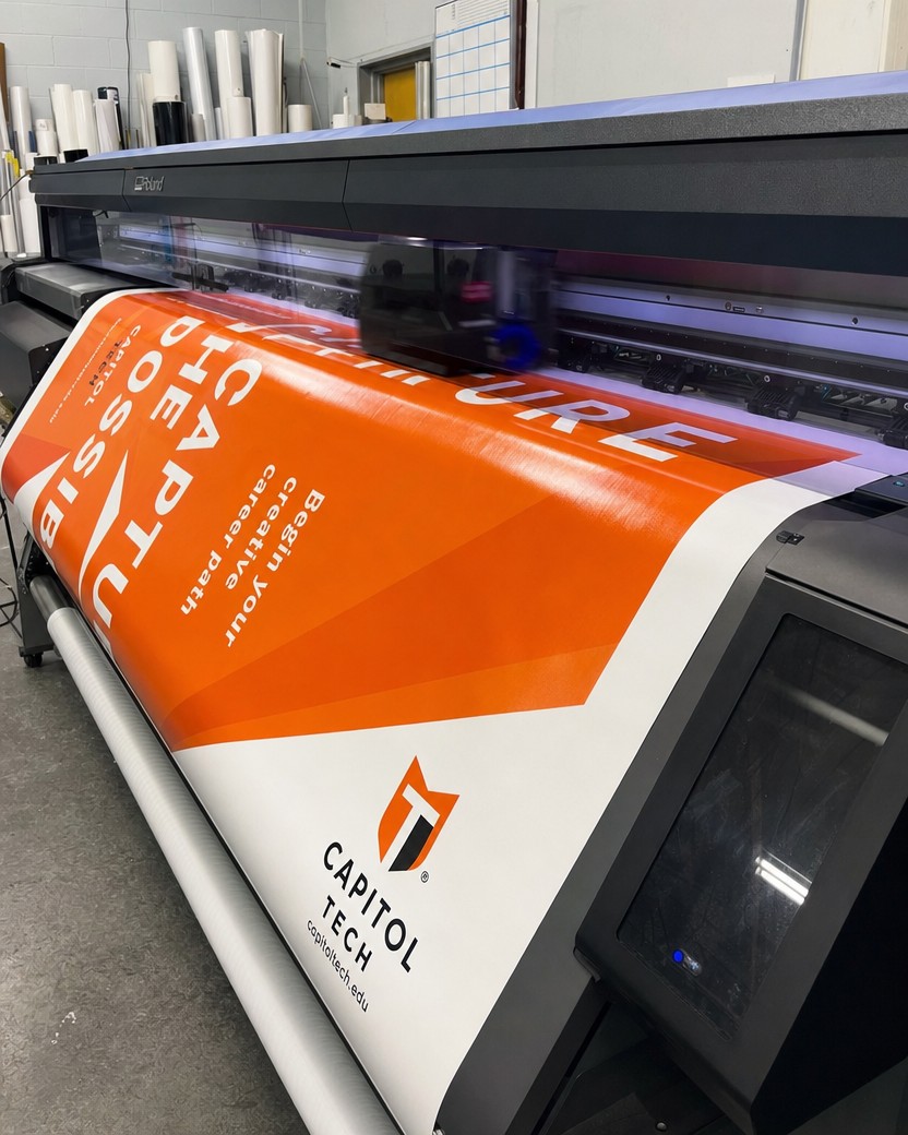 Large-format Roland printer producing a vinyl banner